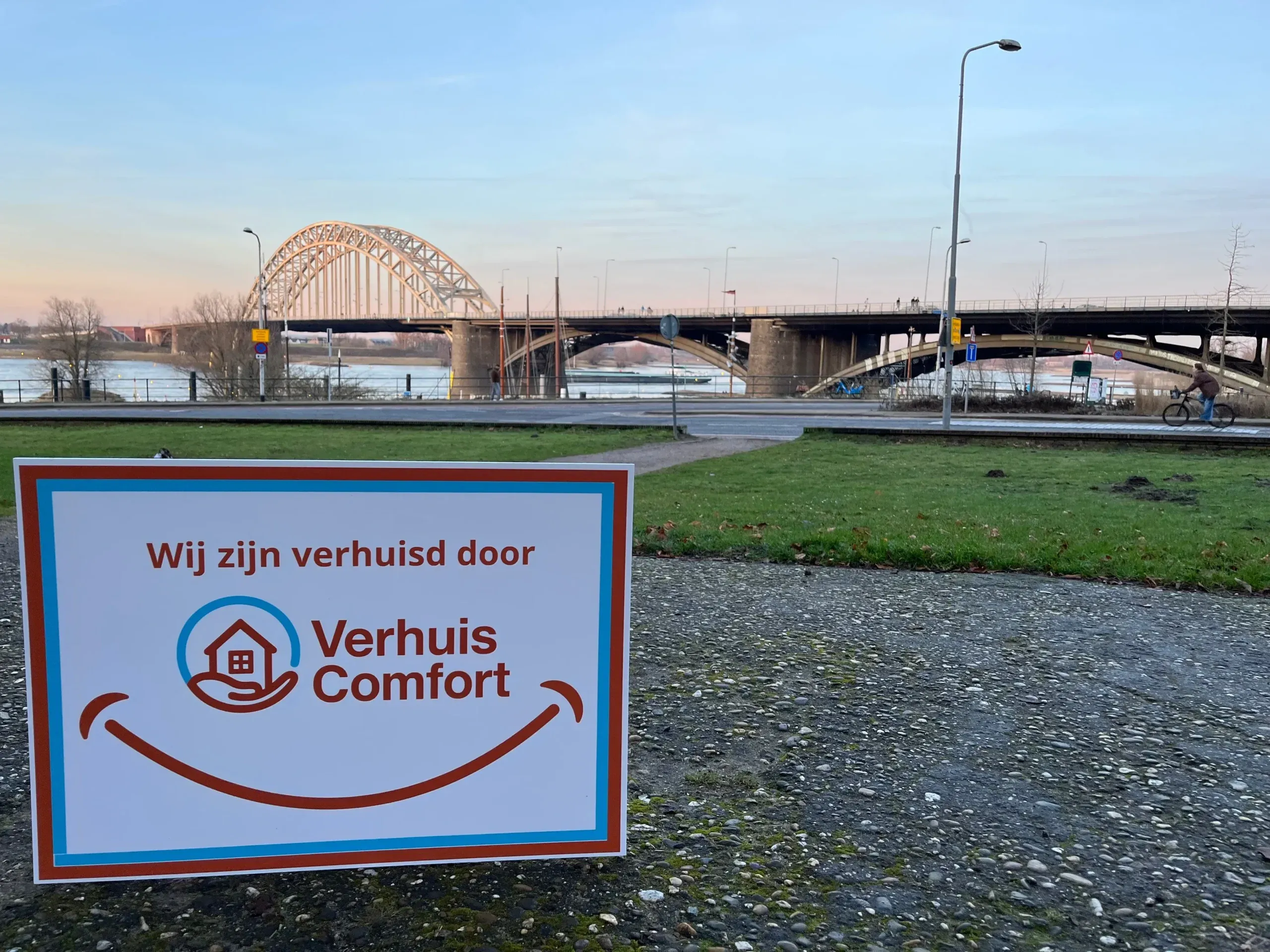 Bord ‘Wij zijn verhuisd door Verhuis Comfort’ bij de Waalbrug in Nijmegen, verhuisbedrijf Nijmegen.